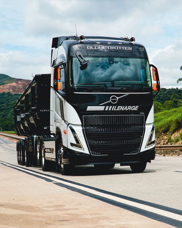 Cavalo mecânico preto da Lenarge com carreta basculante em rodovia