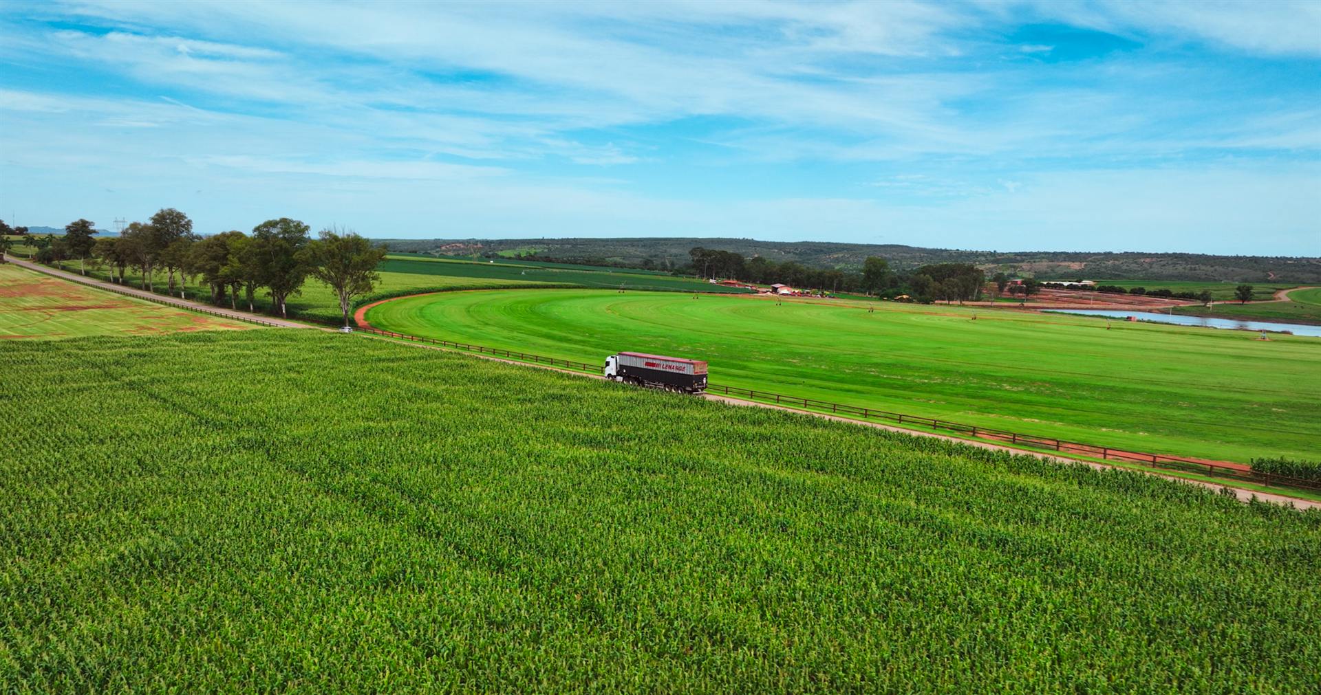 Vista aérea de carreta da Lenarge atravessando lavoura verde sem fim